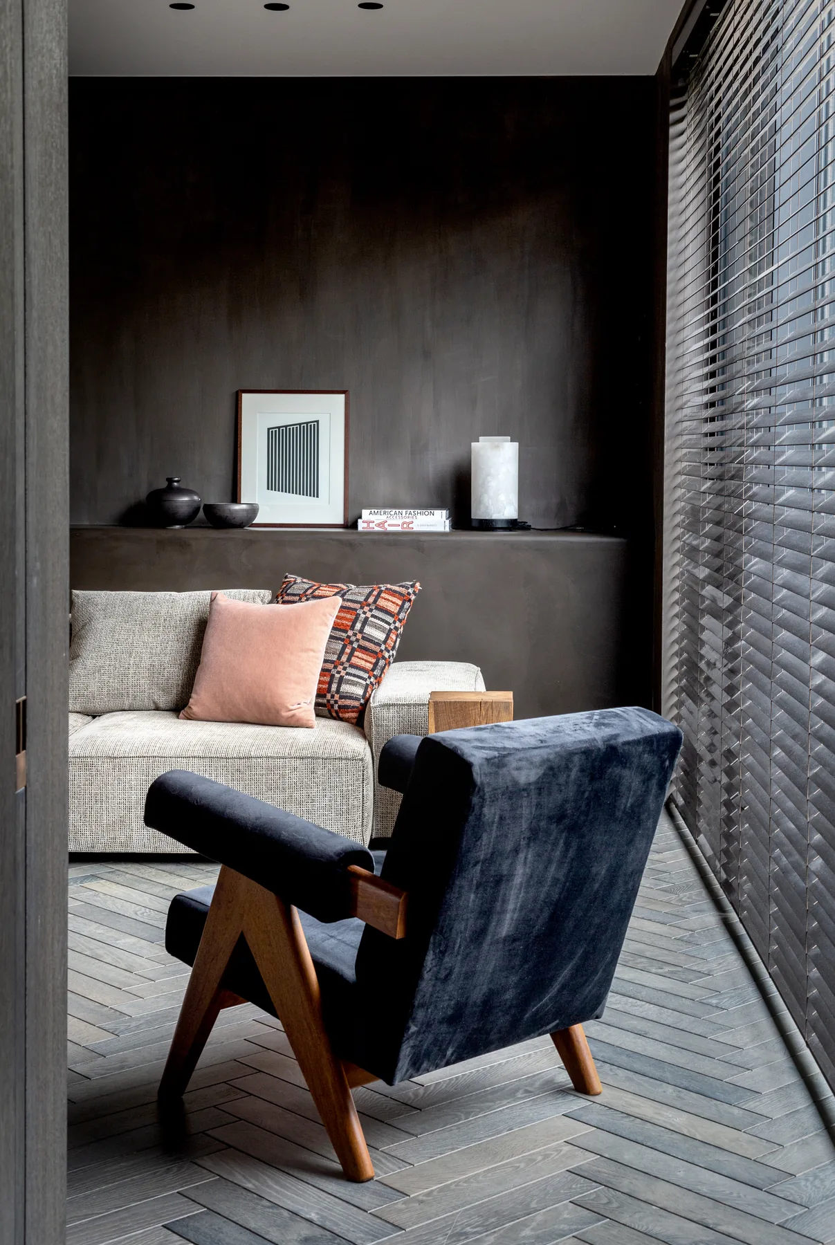 Lounge met donkere wandafwerking en visgraatparket